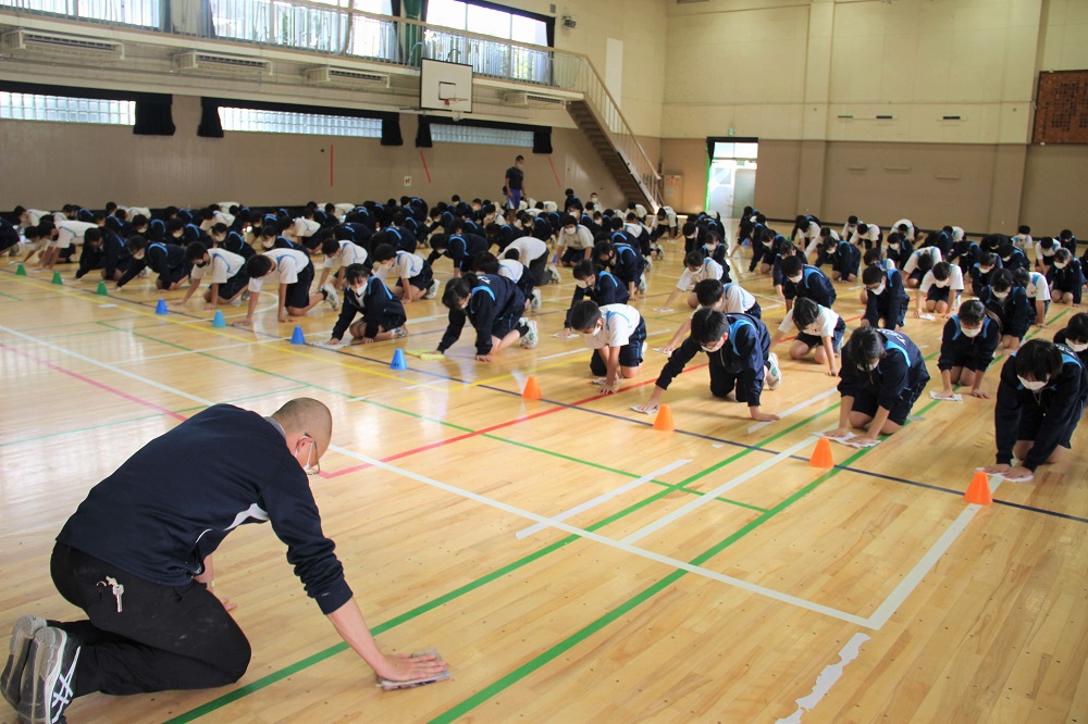 生徒と一緒にふきそうじをする先生